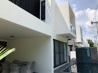 Modern two-story building with outdoor dining area and swimming pool