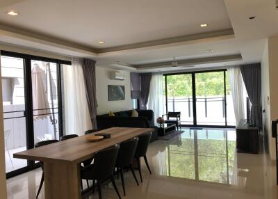Spacious living and dining area with large windows and modern furnishings