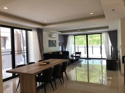 Spacious living and dining area with large windows and modern furnishings