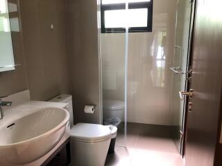 Modern bathroom with sink, toilet, and glass shower enclosure