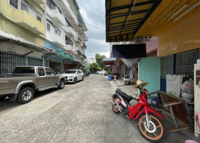 A street view with parked vehicles, buildings, and a motorcycle