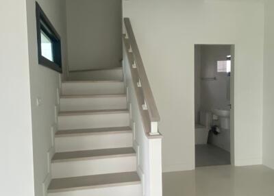 Staircase leading up with a nearby passage to a bathroom