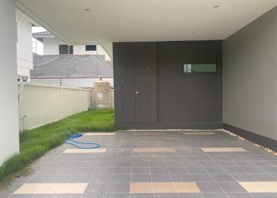 Covered garage space with tiled flooring and garden area