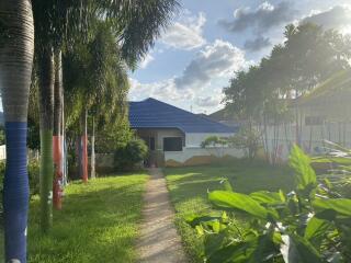 Exterior view of a house with a blue roof and front yard