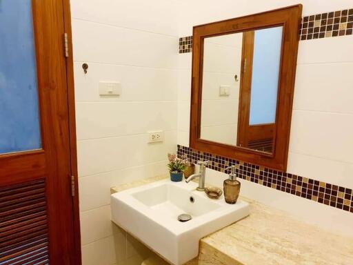 Modern bathroom with sink, mirror, and wooden accents