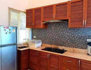 Modern kitchen with wooden cabinets and stainless steel appliances