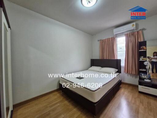 Bedroom with wooden flooring, a bed, wardrobe, and an air conditioner