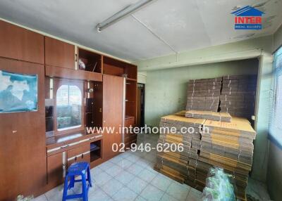 Bedroom with wooden cabinets and stacked mattresses