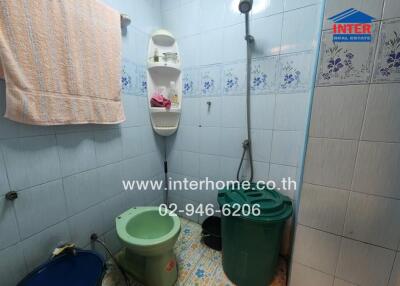 bathroom with tiled walls, shower, and storage shelves