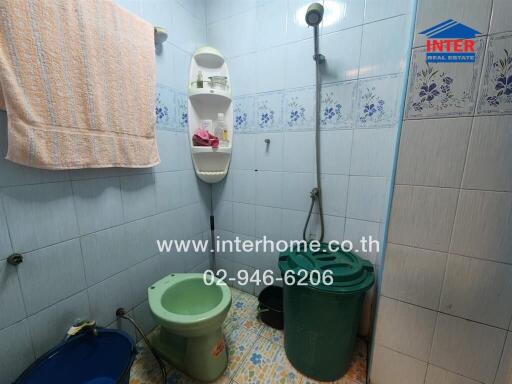 bathroom with tiled walls, shower, and storage shelves