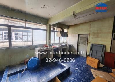 Old kitchen with blue tiled floor and large windows