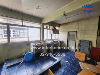 Old kitchen with blue tiled floor and large windows