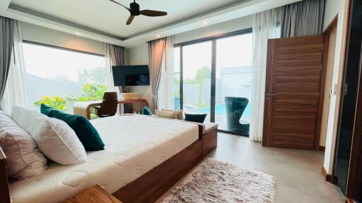 Spacious bedroom with modern furniture and direct pool access