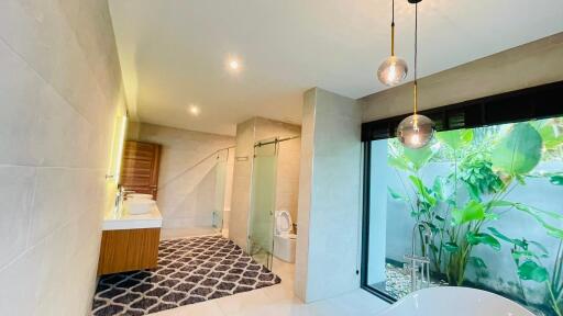 Modern bathroom with large window, open shower, and contemporary fixtures