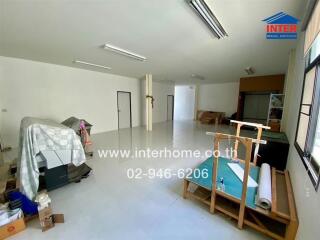 Spacious room with covered furniture and scattered items