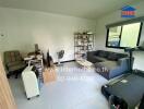 Living room with a couch, treadmill, desk, and shelves