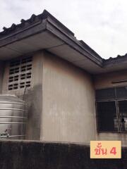 Exterior view of a building with a water tank and weathered walls.