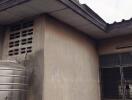 Exterior view of a building with a water tank and weathered walls.