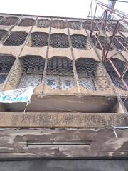 Facade of an unfinished building with unique window grills