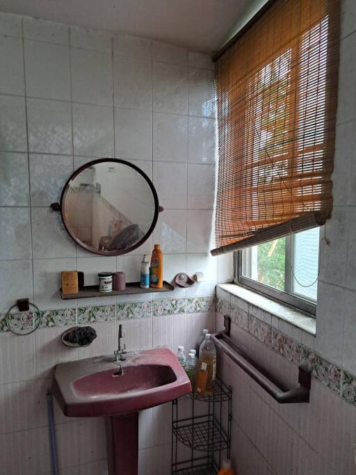 Bathroom with a mirror, sink, and window with blinds