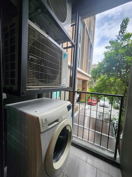 Laundry area with a washing machine and outdoor view