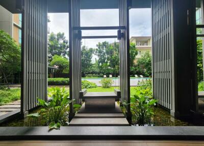 Modern building entrance with water feature and greenery