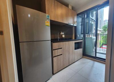 Modern kitchen with fridge and wooden cabinets