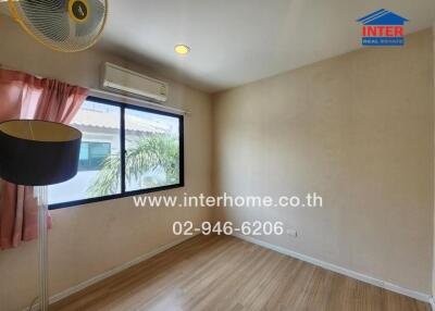 Small bedroom with a window, air conditioner, and wooden floor