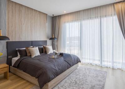 Spacious modern bedroom with large window and king-sized bed