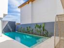 Modern outdoor pool area with plants and wicker furniture