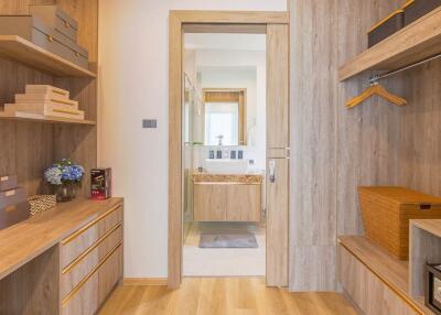 Organized bedroom with open wardrobe and bathroom entrance