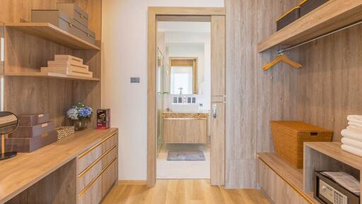 Organized bedroom with open wardrobe and bathroom entrance