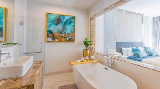 Modern bathroom with a bathtub and a view into a bedroom