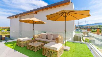 Modern outdoor terrace with wicker furniture and parasols