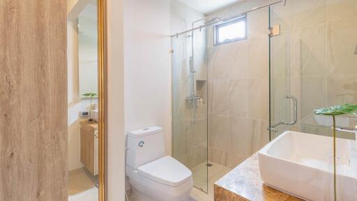 Modern bathroom with glass shower door, toilet, and sink