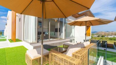 Modern outdoor seating area with wicker furniture and parasols