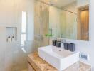 Modern bathroom with sink, glass shower, and amenities