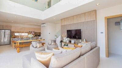 Modern open-plan living and dining area with a kitchen in the background