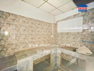 Kitchen area with tiled countertops and backsplash