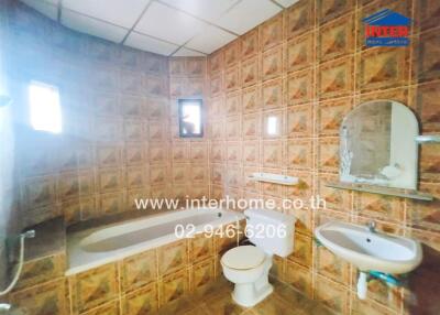 Bathroom with bathtub and tiled walls