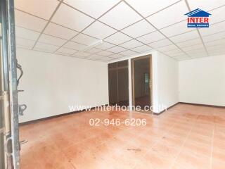 Spacious empty room with tiled floor and contact information