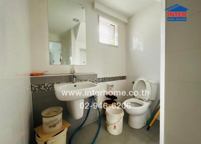 Bathroom with sanitary fixtures and cleaning supplies