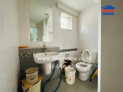 Bathroom with sanitary fixtures and cleaning supplies