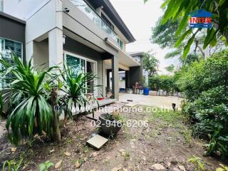 Front yard of a modern house with patio and greenery