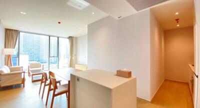 Modern living area with dining table, chairs, and large windows