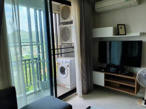 Living area with balcony view, air conditioning, and entertainment setup