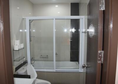 Modern bathroom with enclosed bathtub and toilet