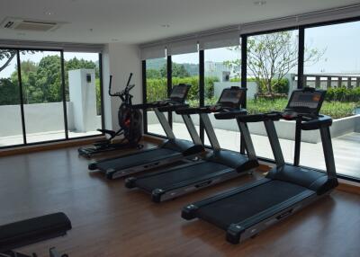 Fitness center with treadmills and large windows showcasing outdoor greenery