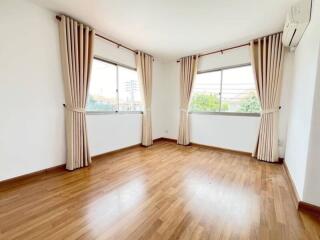 Bright living room with wooden floor and large windows