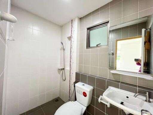 Modern bathroom with shower, toilet, and sink.